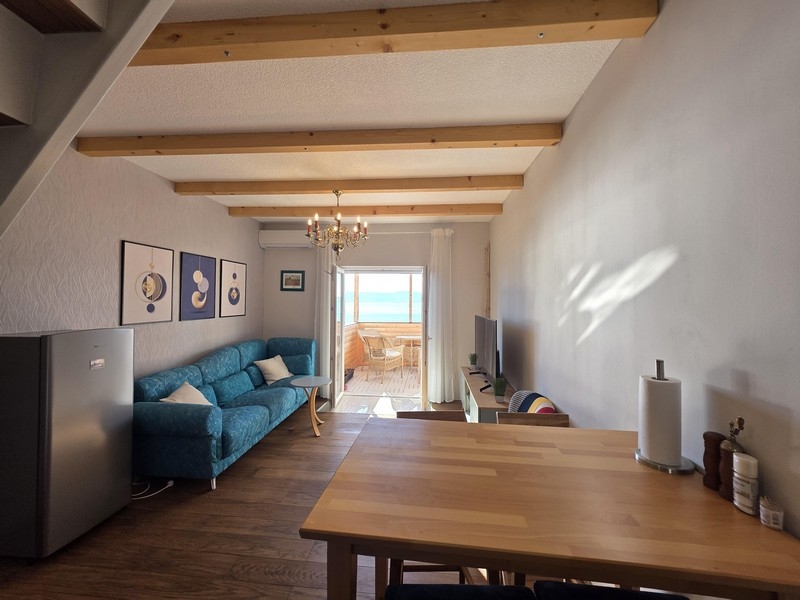 Vardagsrum med soffa och havsutsikt från balkongen