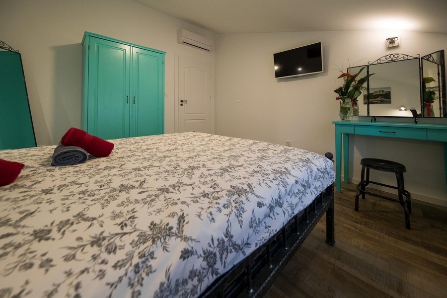 Sovrum med dubbelsäng och väggspegel