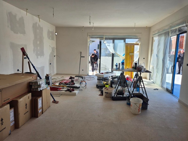 Vardagsrum med byggmaterial och tillgång till altan