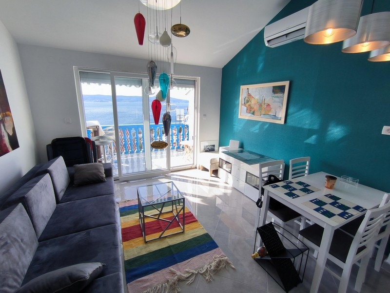 Vardagsrum med färgglad belysning och havsutsikt