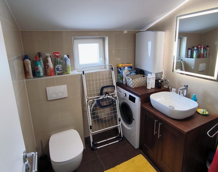 Badrum med tvättmaskin och modern inredning
