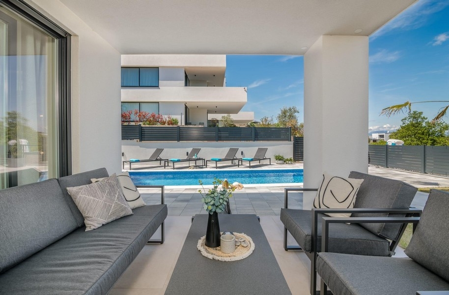 Terrass med poolutsikt och solstolar