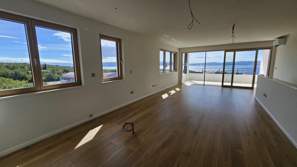 Rymligt vardagsrum med havsutsikt och fönster från golv till tak