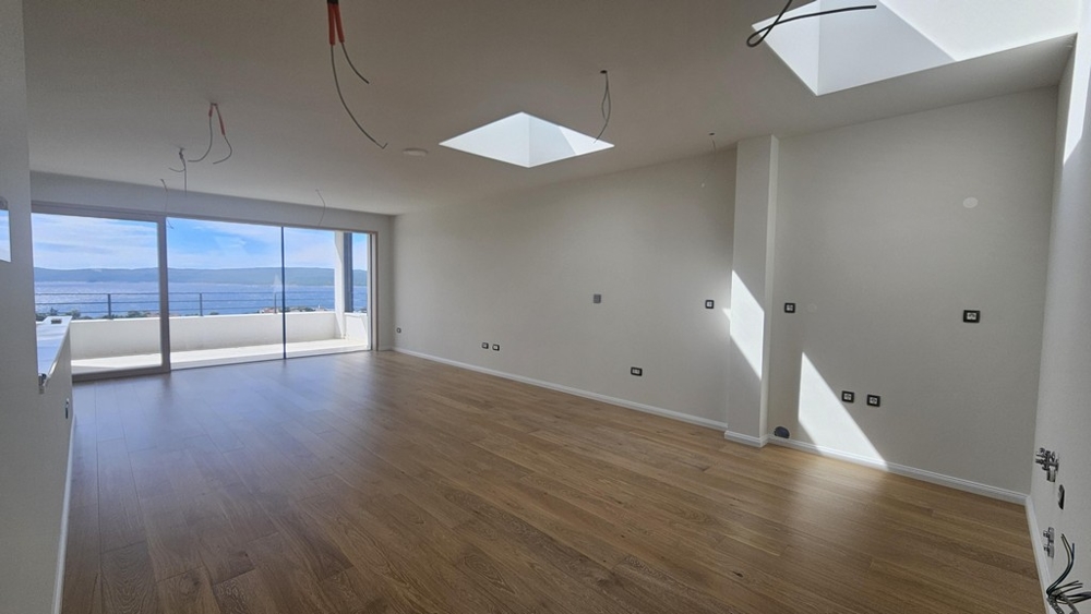 Ljust vardagsrum med havsutsikt och parkettgolv