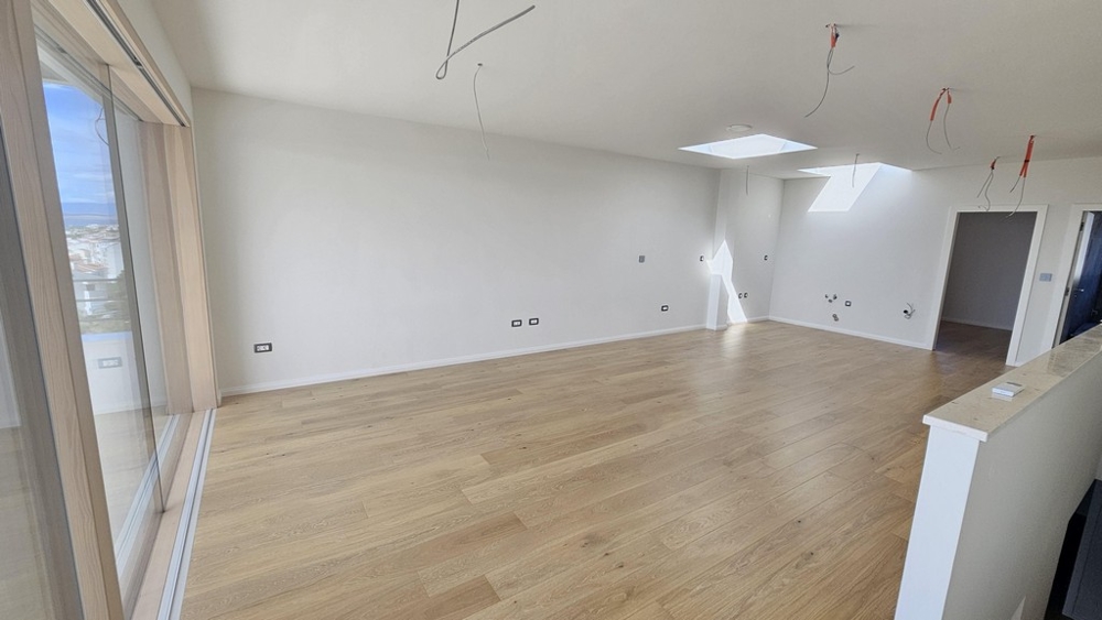 Öppen vardagsrumsdel med stora fönsterpartier och utgång till balkong