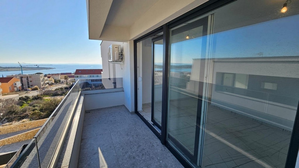 Terrass med glasräcken och havsutsikt