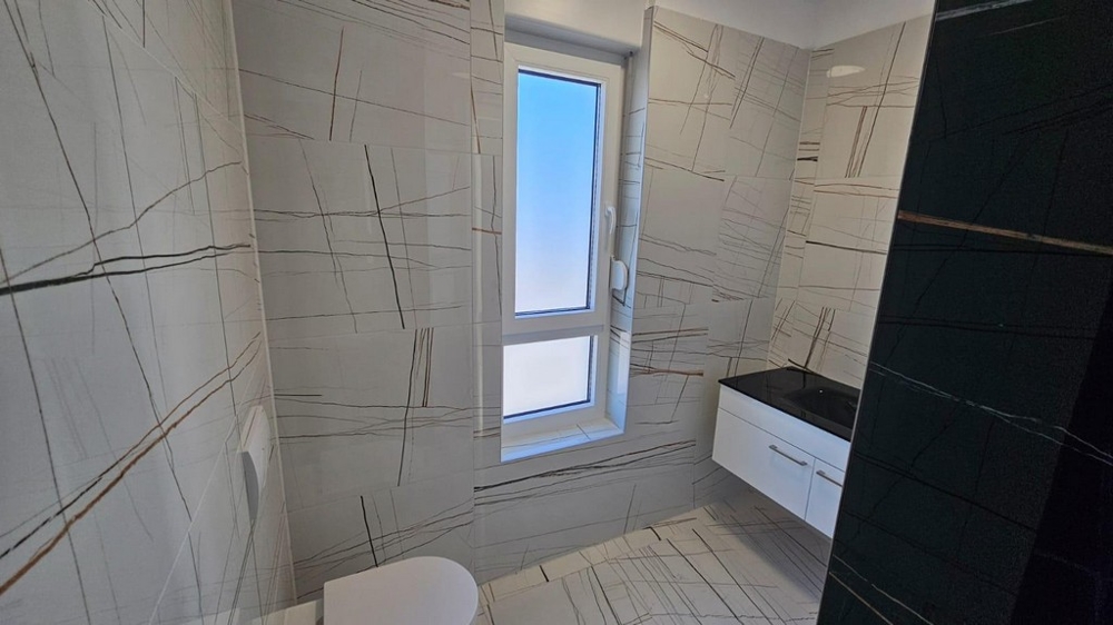 Badrum med modern kakeldesign och fönster