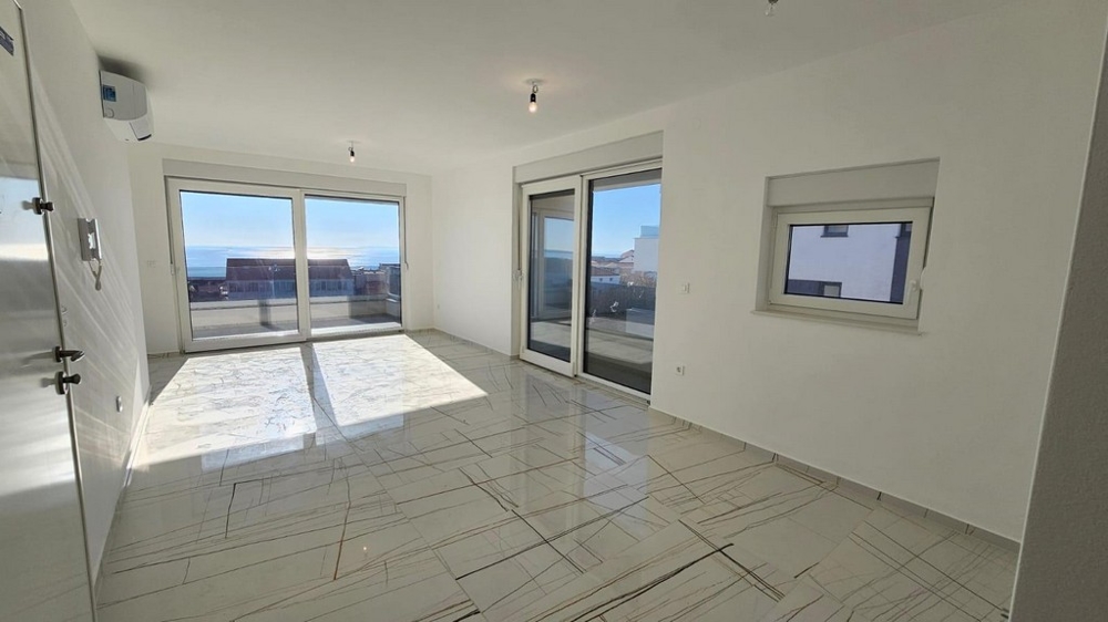 Ljust vardagsrum med stora fönster och havsutsikt