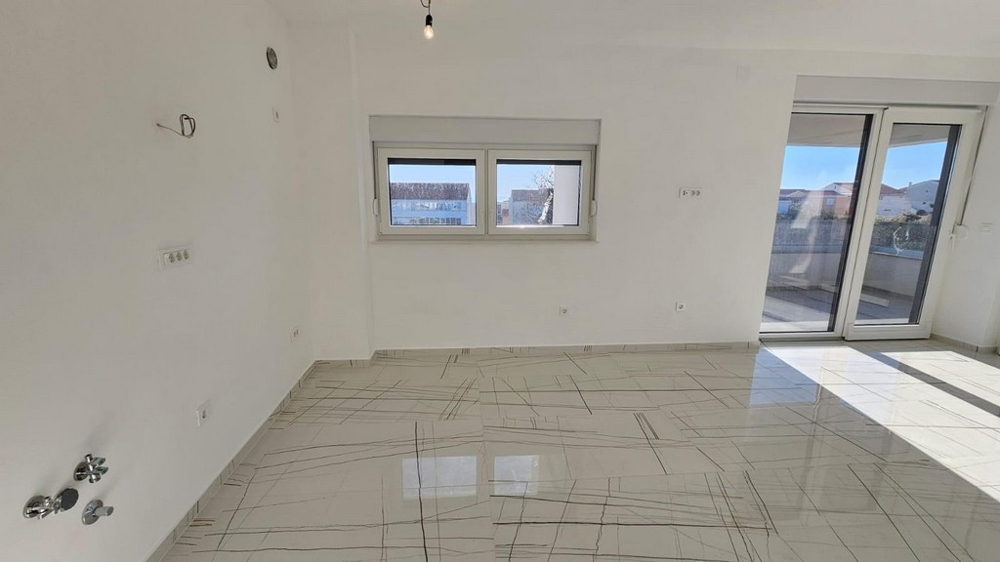 Vardagsrum med klinkergolv och utgång till altan