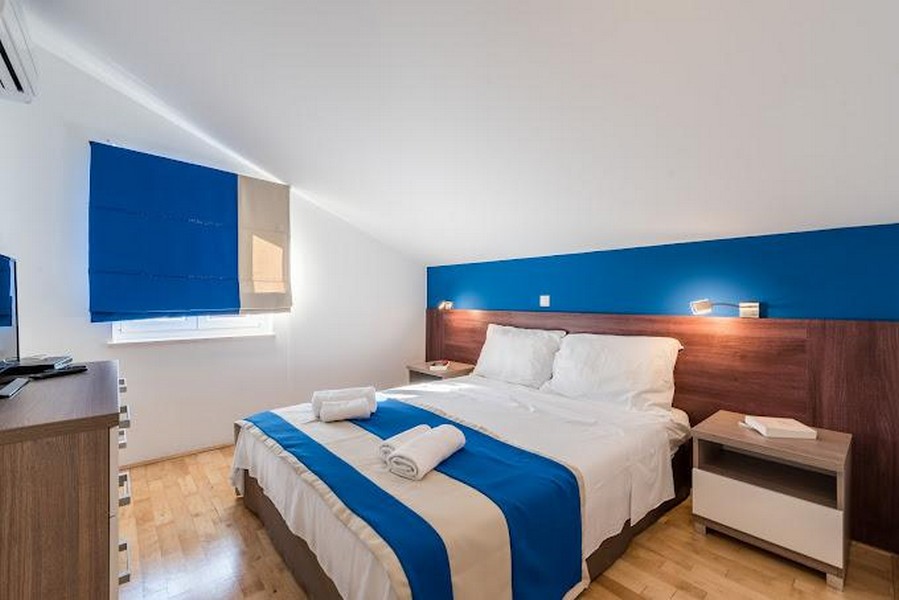 Sovrum med dubbelsäng och blå accenter