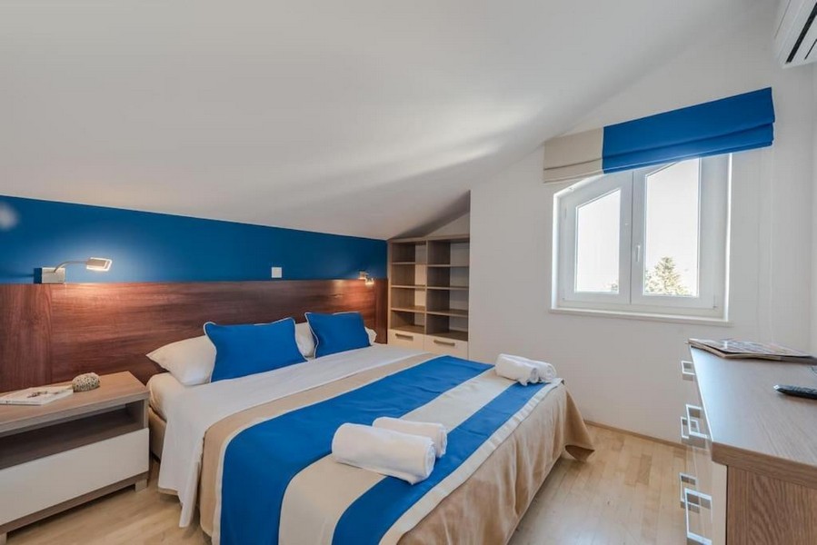 Andra sovrummet med stor säng och fönster