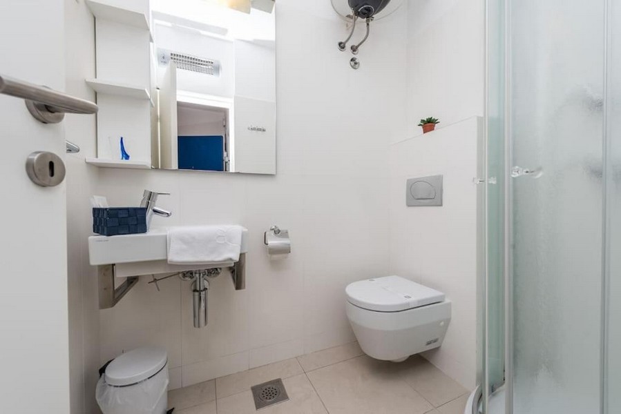 Badrum med dusch och vitt kakel