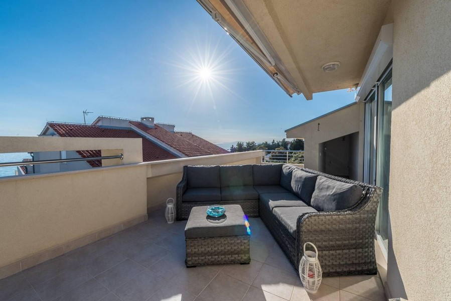 Solig takterrass med sittgrupp och havsutsikt