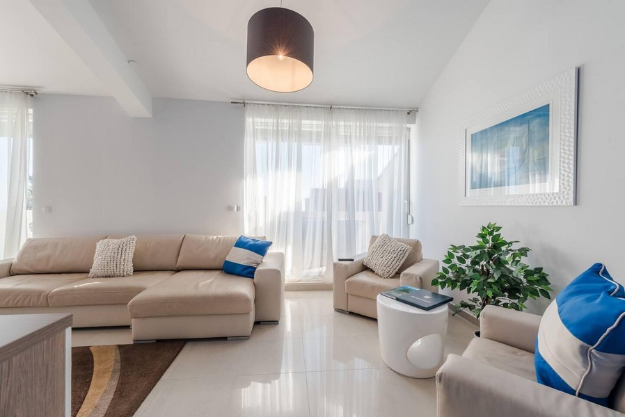 Ljust vardagsrum med stora fönsterpartier