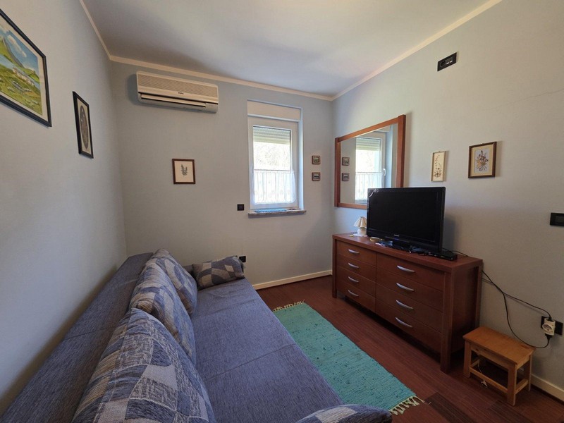 Sovrum med soffa, byrå och tv