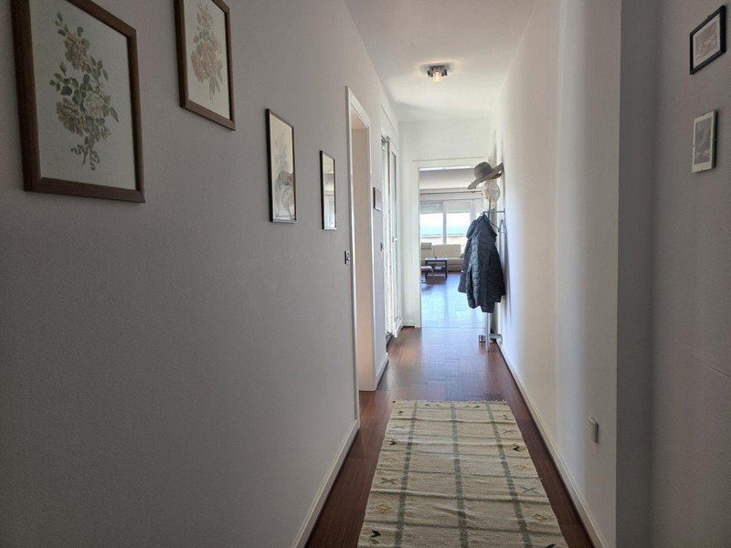 Hall med väggdekorationer och utsikt in i vardagsrummet