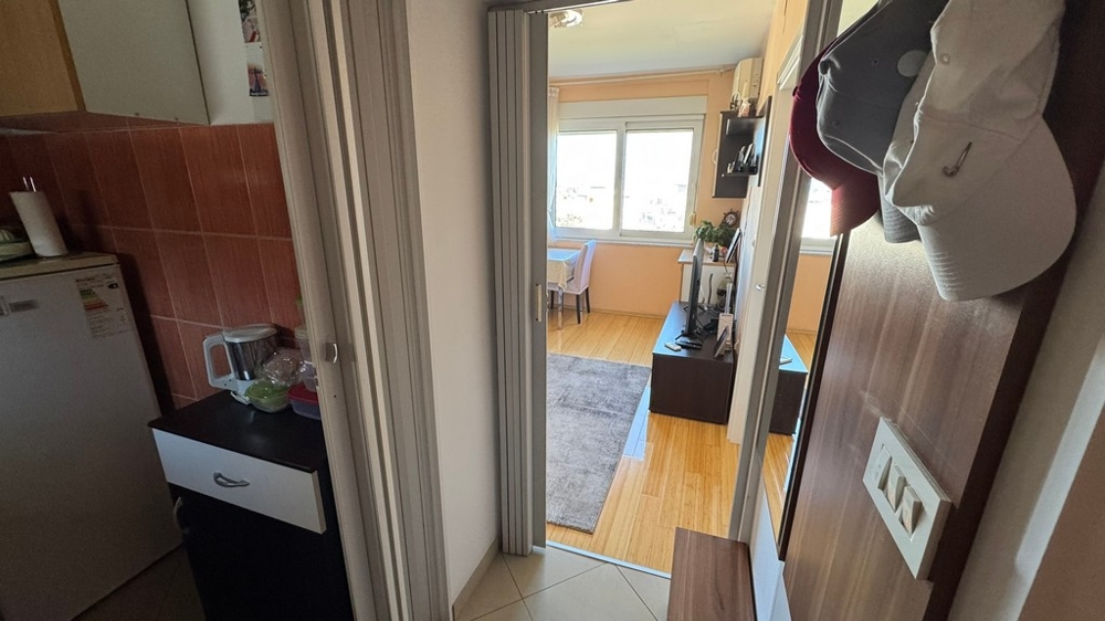 Entré med utsikt över vardagsrum och pentry till vänster