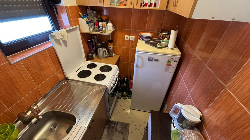 Litet kök med spis, diskho och kyl