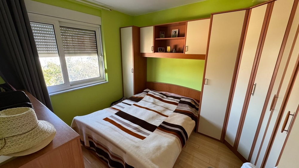 Sovrum med dubbelsäng och inbyggda garderober, gröna väggar