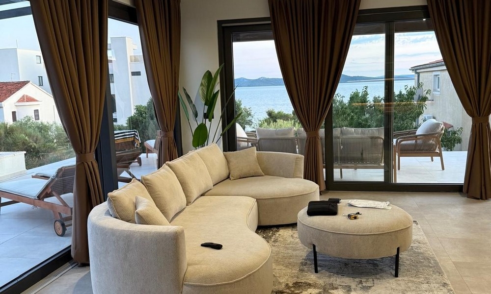 Vardagsrum med stort fönsterfront och havsutsikt