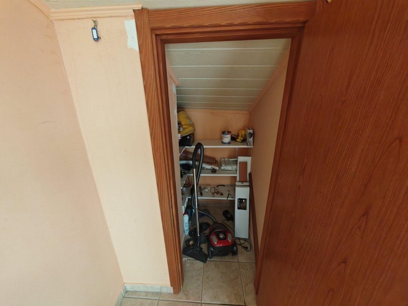 Litet förråd med hyllor och dammsugare