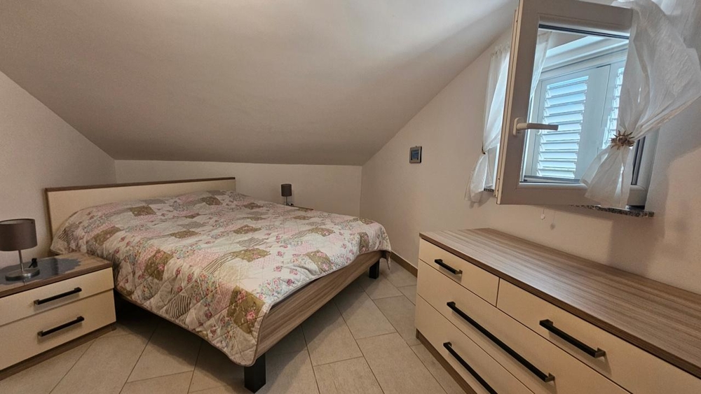 Sovrum med dubbelsäng och byrå