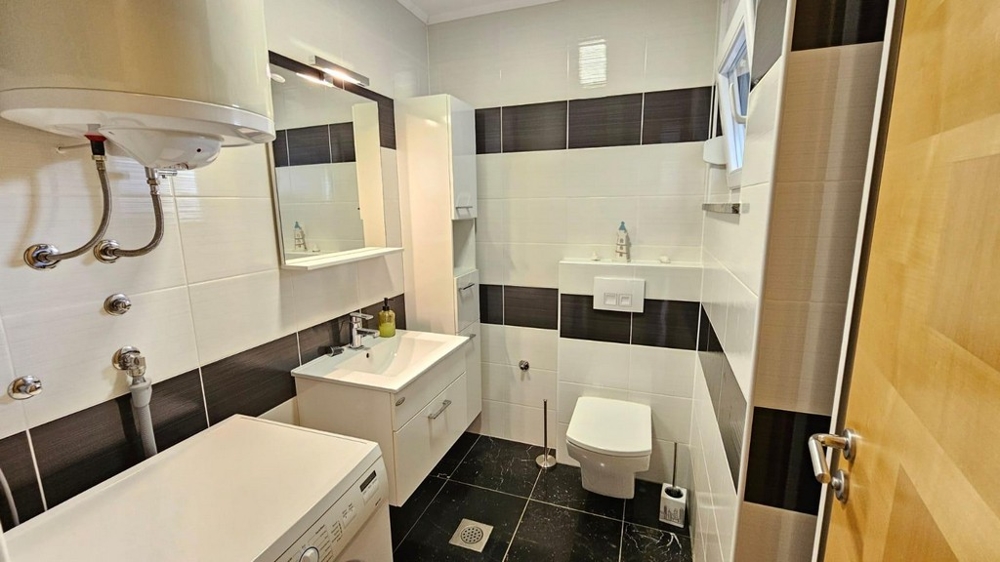 Modernt badrum med dusch och tvättmaskin