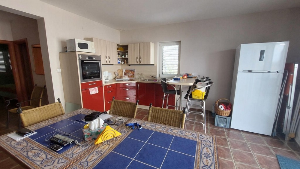 Vardagsrum med kök och stort matbord