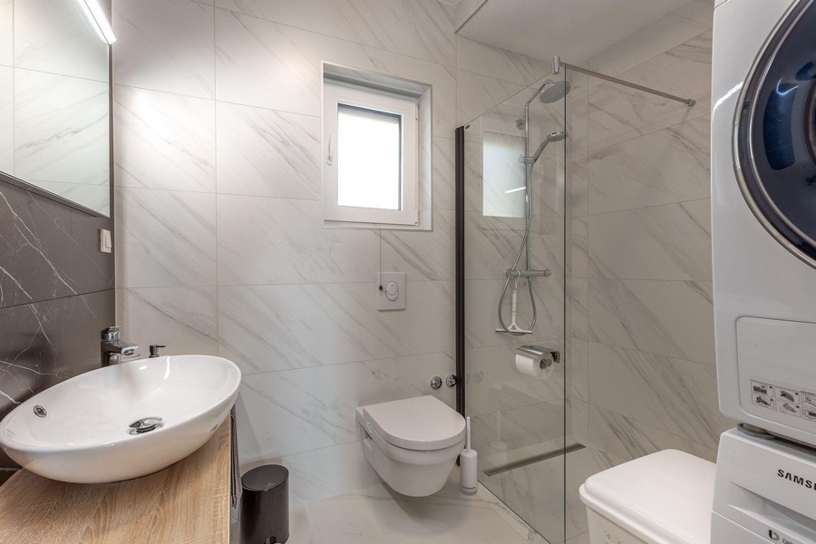 Badrum med dusch och tvättmaskin