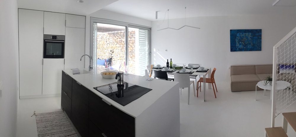 Modernt kök med matplats och utgång till altan