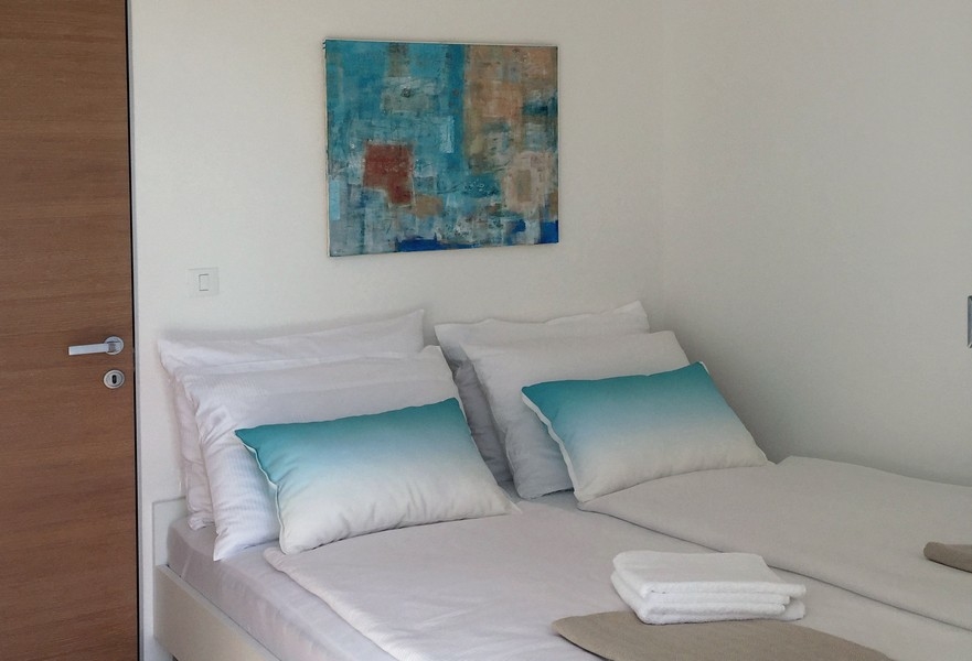 Sovrum med dubbelsäng och väggmålning