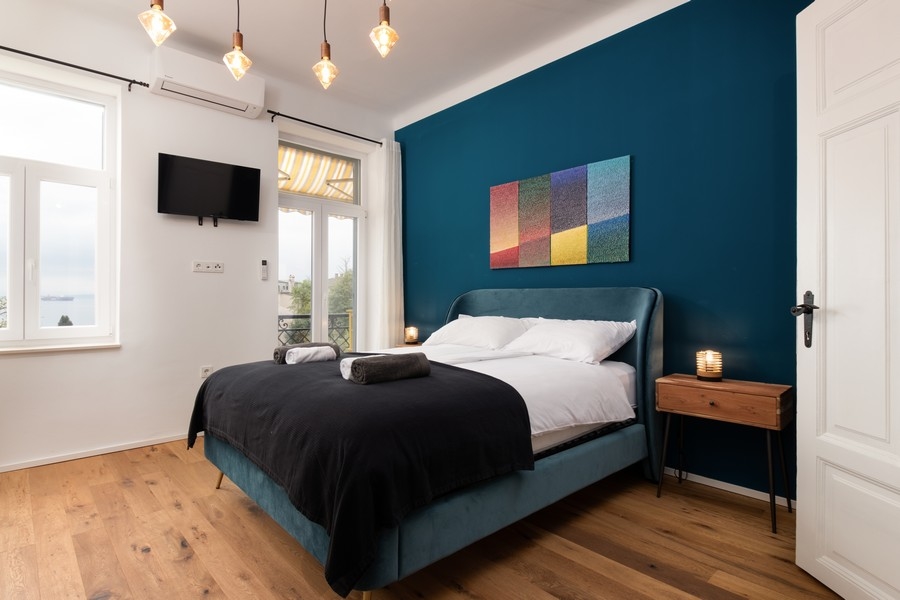 Sovrum med havsutsikt och mörkblå vägg