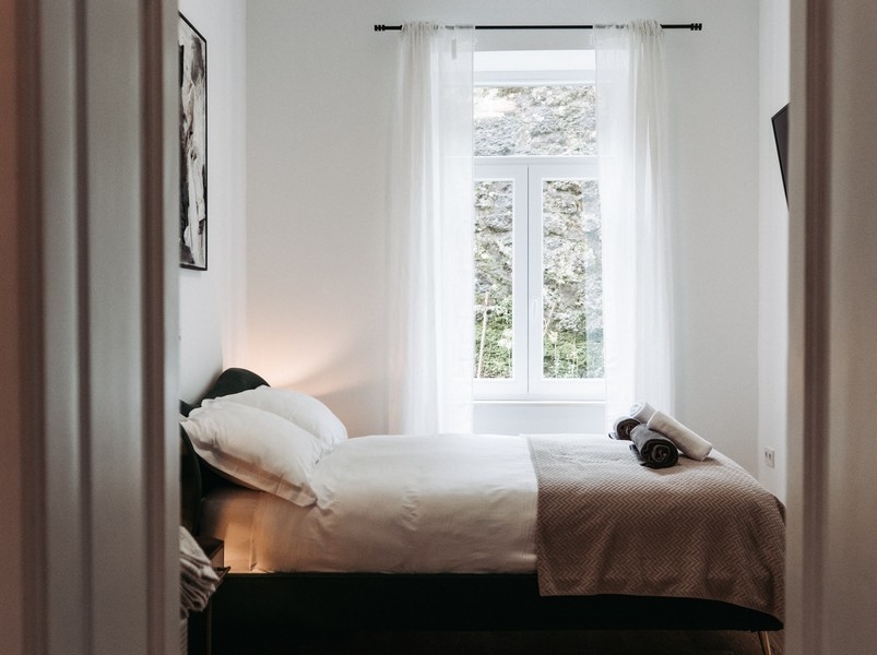 Sovrum med enkelsäng och ljusa gardiner