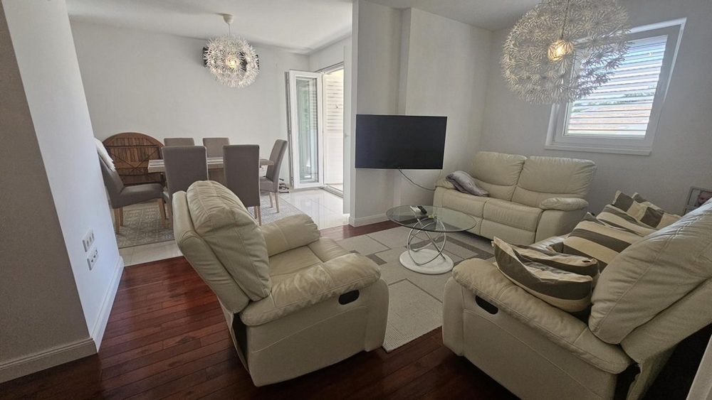 Vardagsrum med skinnsoffa och TV