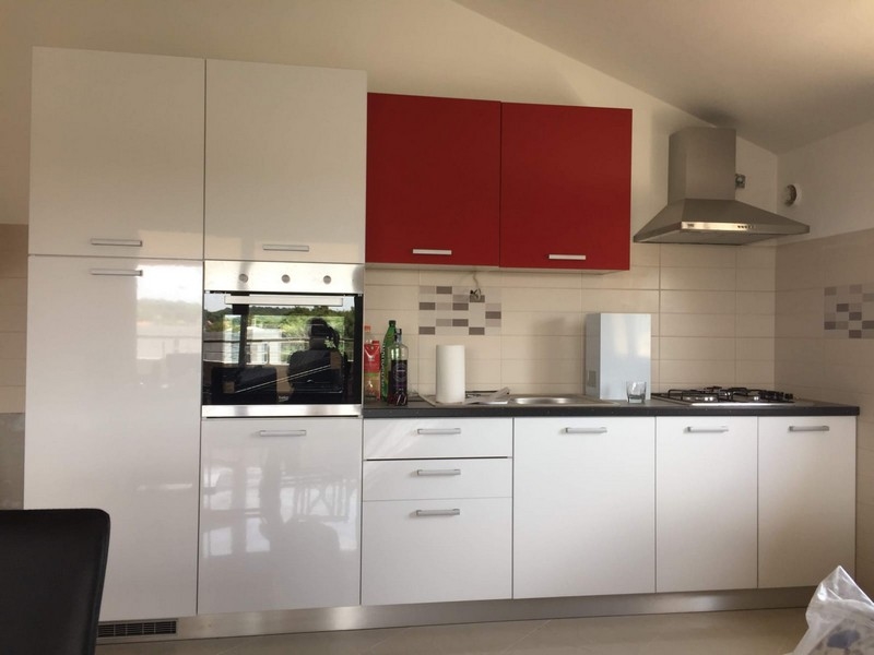 Utrustat kök med röda överskåp