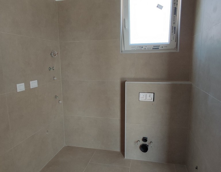 Modernt kaklat badrum med fönster och anslutningar