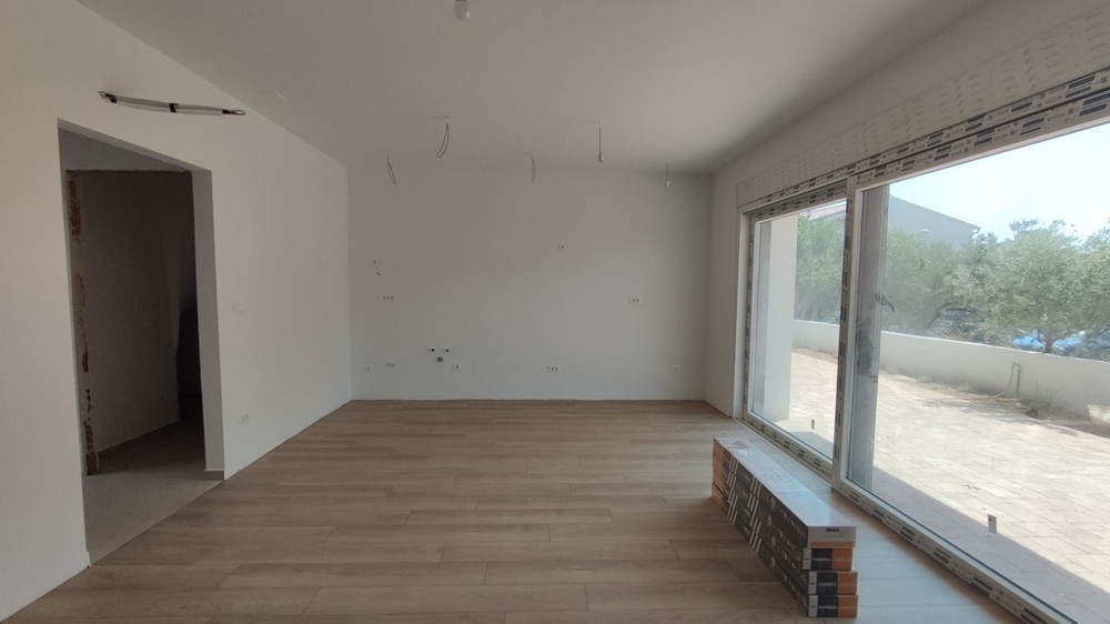 Samma vardagsrum med stort fönsterfront