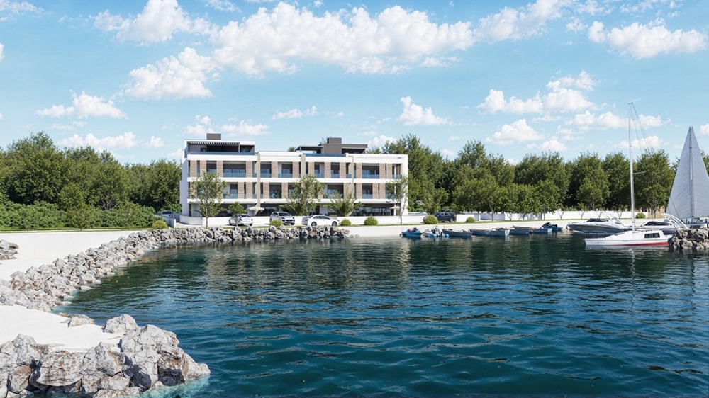 Visualisering av bostadskomplexet direkt vid kusten med en båtbrygga