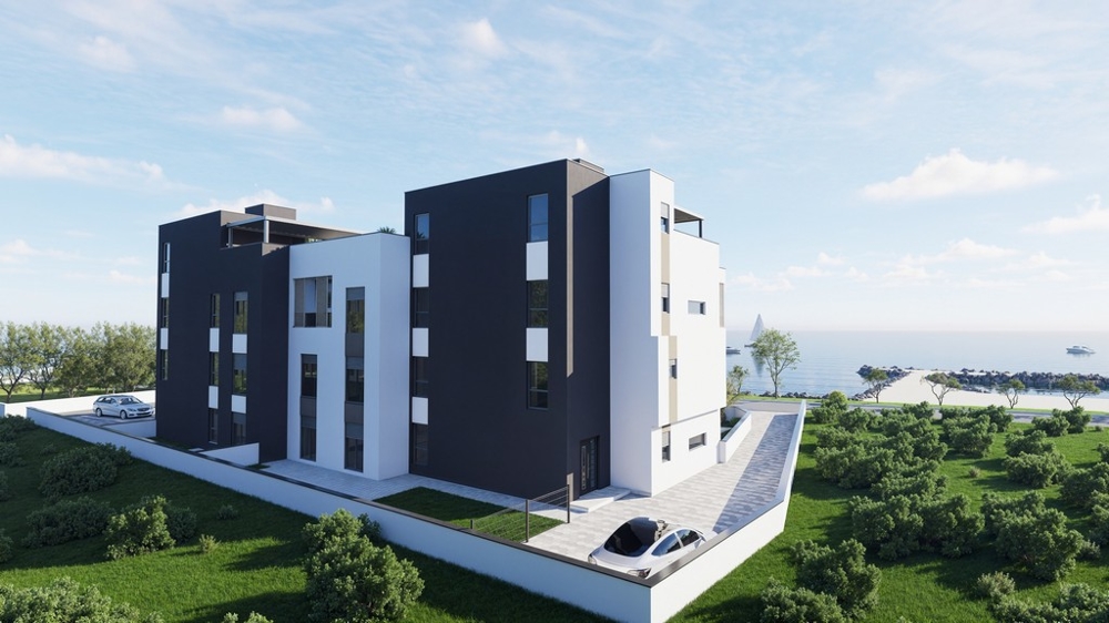 Bakifrån av den moderna nya byggnaden med parkeringsplatser och havsutsikt