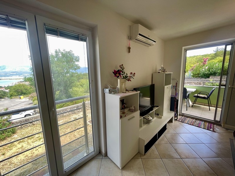 Möblerat vardagsrum med utsikt över havet.