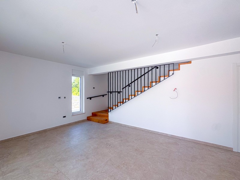 Vardagsrum med modern trappa till övervåningen i fastighet A3699.