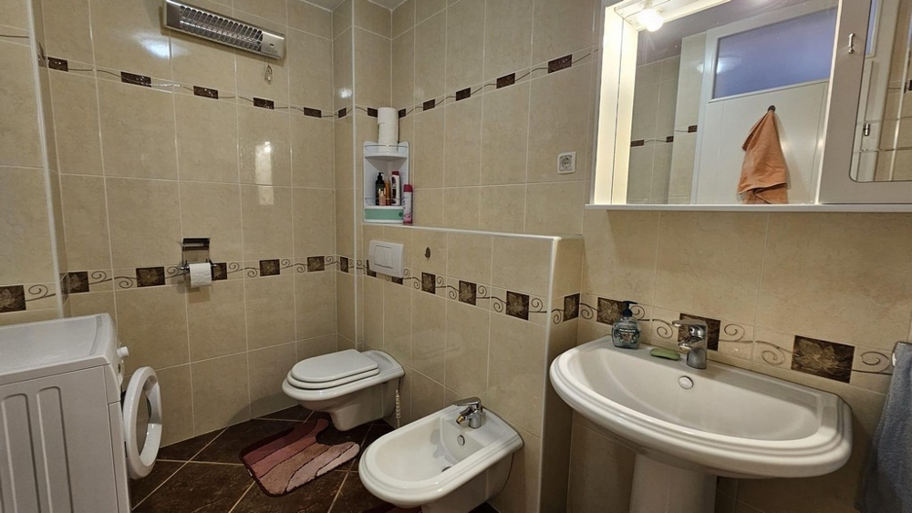 Badrum med tvättmaskin och bidé