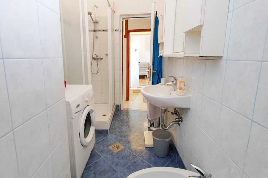 Badrum med dusch och tvättmaskin