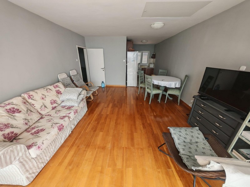 Vardagsrum med parkett och TV