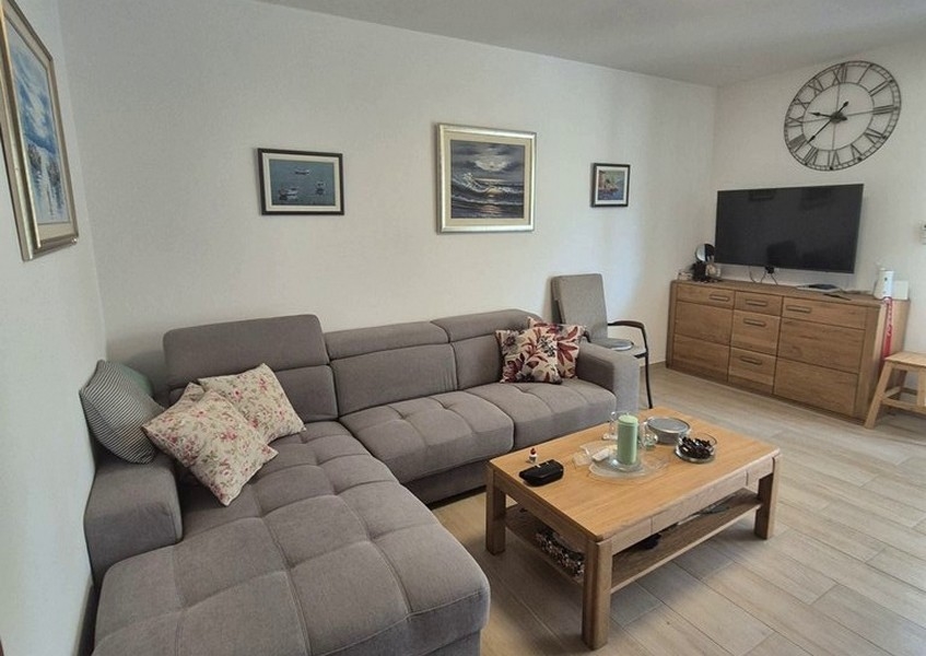 Vardagsrum med grå hörnsoffa och soffbord