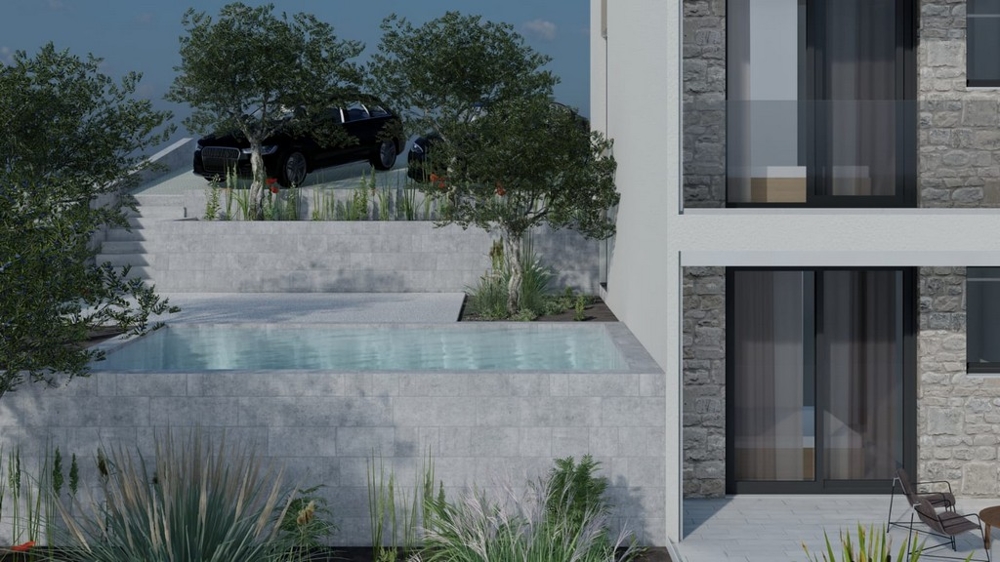 Pool framför byggnaden med grönska och parkeringsplatser