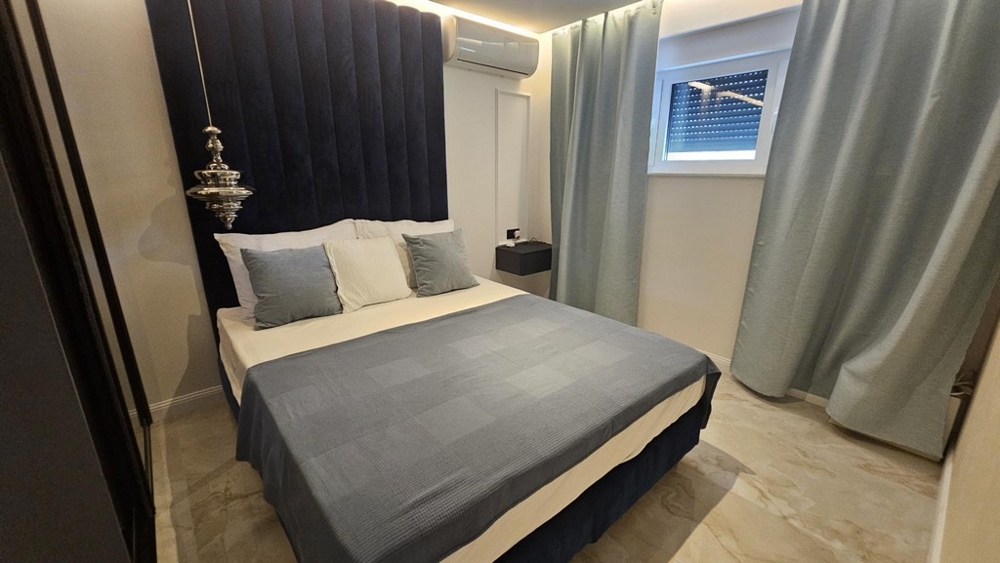 Sovrum med dubbelsäng och mörkblå sänggavel