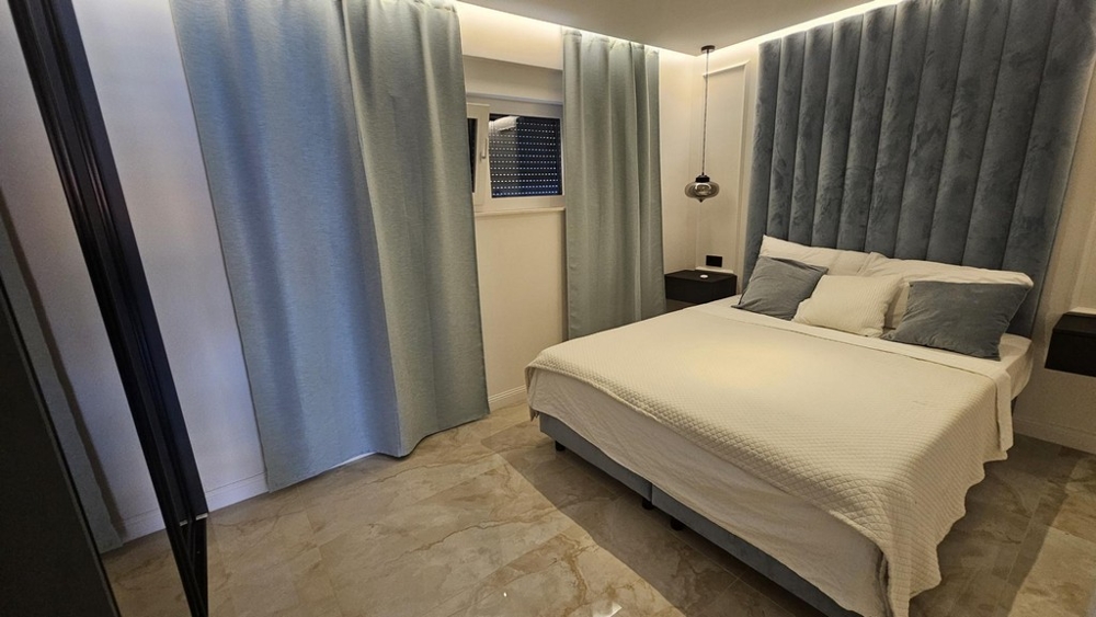 Sovrum med dubbelsäng och ljusblå sänggavel