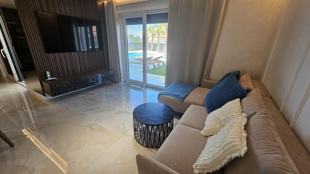 Vardagsrum med soffa, soffbord och utgång till terrassen