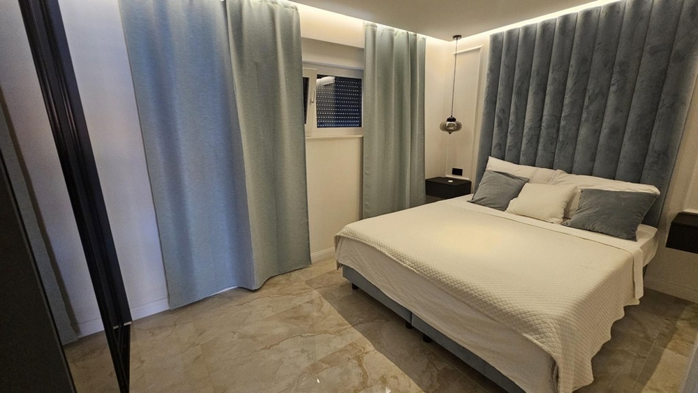 Sovrum med dubbelsäng och ljusblå gardiner